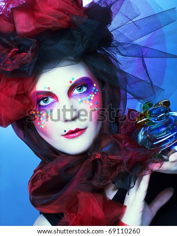 Young lady with bright make-up in doll-style with glass box and beads in it