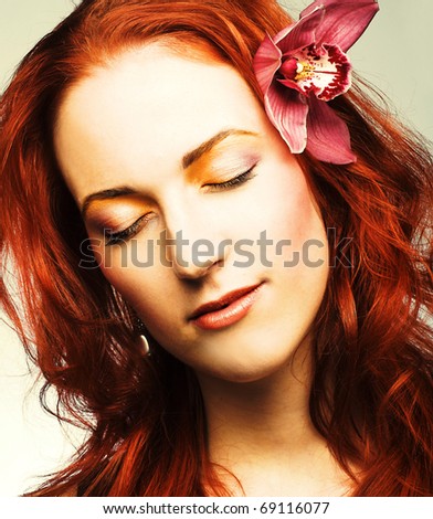 Young woman with pink orchid in her hair