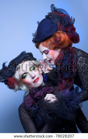 Two young ladies in vintage hats and corsets and with  artistic creative make-up