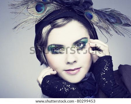 Portrait of young woman witn creative make-up and in vintage hat.