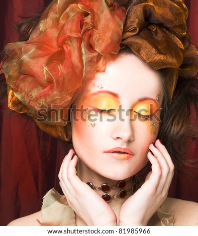 Young woman in creative image in retro style with orange and gold accessories