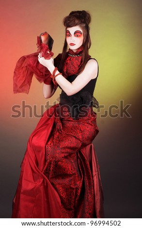 Sorceress. Lady in black and red dress and with fragment of mirror.