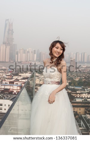 bride standing  ouside with huangpu river, traditional Chinese wedding