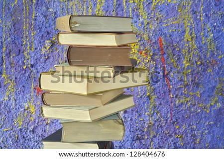 stack of vintage books, against purple background