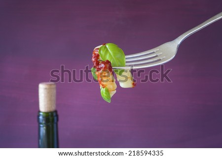 Italian food, pasta with tomato sauce, basil and wine bottle