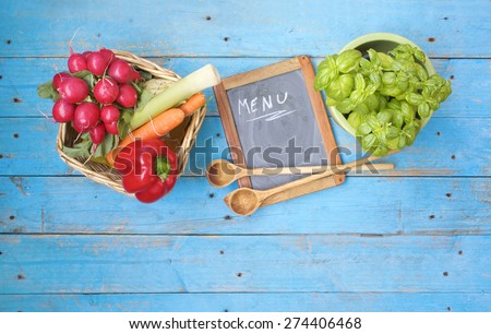 menu w. food ingredients, black board and kitchen utensils, free copy space