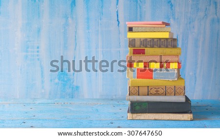 stack of books on grungy background, panoramic format, free copy space