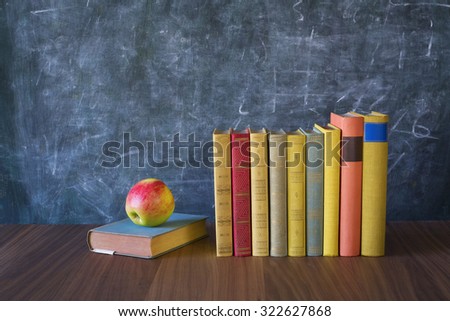 books and apple in front of a black board, learning, back to school,reading, literature