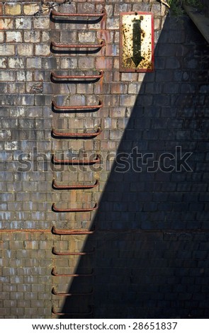 rusty rungs in a brick wall w. arrow facing downwards, diagonal shadow great for filling in copy, grunge background