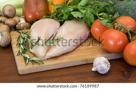 Fresh raw chicken fillets and vegetables prepared for cooking