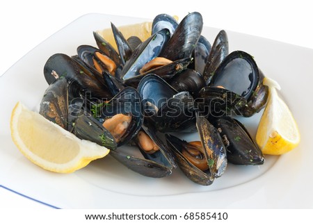 cooked mussels on a plate with lemon isolated on white with clipping path