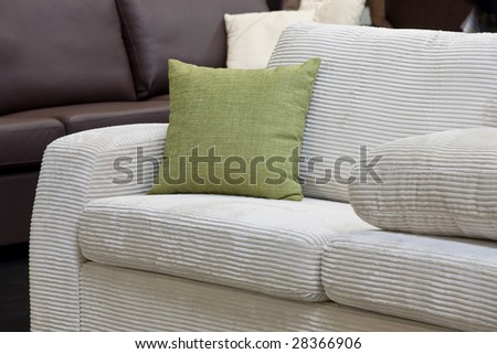 Green pillow on the white velveteen sofa
