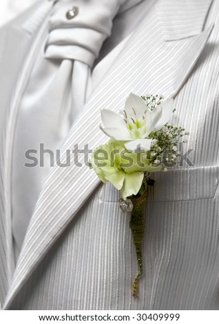Closeup shot of flower in buttonhole. Groom suit