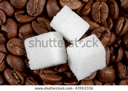 Three pieces of sugar on the roasted coffee beans
