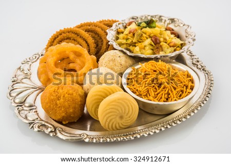 Diwali food or Diwali snacks or Diwali sweets in silver plate isolated on white background