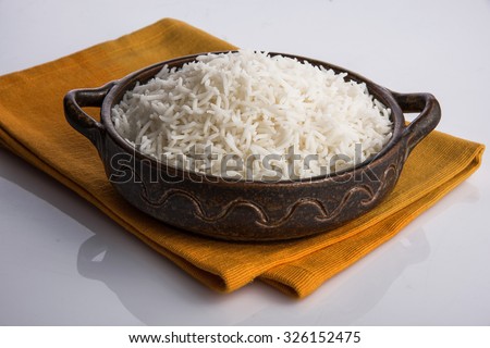 cooked white rice in a bowl, plain basmati rice, on an orange napkin over a white background