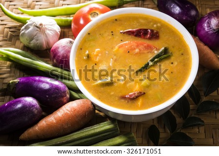south indian vegetable sambar, with vegetables isolated on wooden ken background