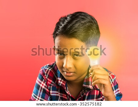 10 year indian boy holding glowing light bulb in hand, creativity concept, science concept, idea clicking expressions, indian boy, asian boy, red background, front profile, closeup