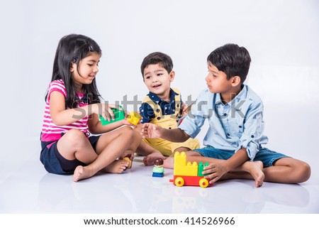 indian kids playing with block toys, asian small kids playing indoor games, colorful plastic block toys, making toy house, over white background, indian small girl and indian small boy playing blocks