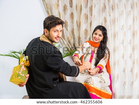 Indian young sister tying rakhi on brother\'s wrist, a tradition on Raksha Bandhan festival