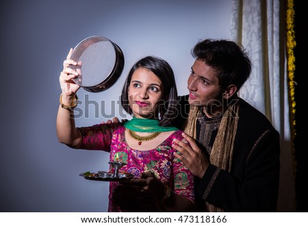 Young Indian woman celebrating Karwa chauth festival with husband