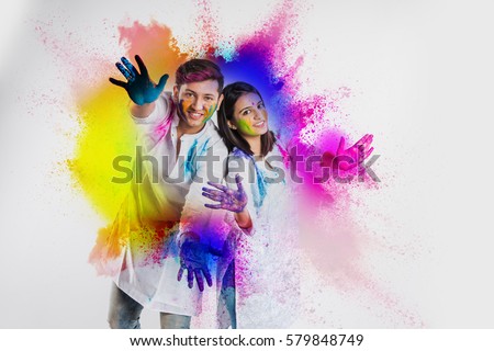 indian couple celebrating holi with colour splash showing colourful or painted palm