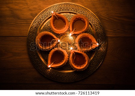Diya in Thali - Brass Plate or thali full of Terracotta diya or oil lamps ready for decorating or illuminating house on diwali, a festival of light. selective focus