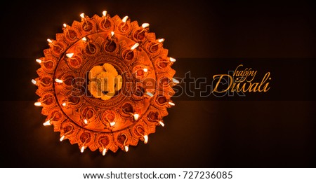 Happy Diwali greeting card design using Beautiful Clay diya lamps lit on diwali night Celebration.  Indian Hindu Light Festival called Diwali, a festival of light