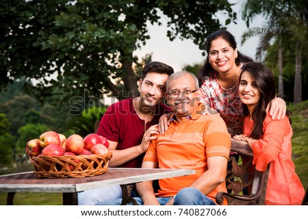 group photo of happy indian family sitting over lawn chair