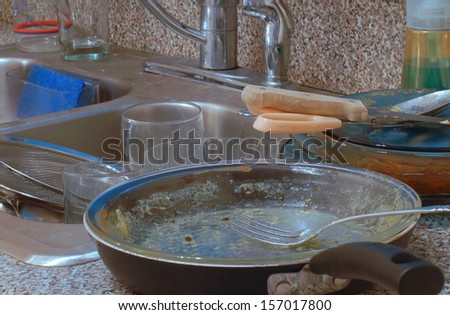 Very messy kitchen with piles of dirty dishes