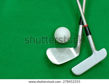 Golf club and golf ball on green felt background. Copy space for your message on the green felt background. Putter club and ball are positioned to the right of the image, room for text on the left
