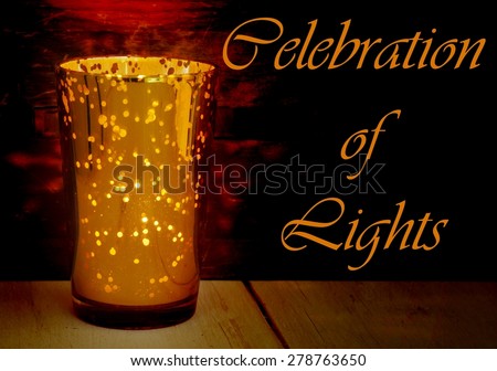 Low key image of a golden glass candle holder with many points where light can come through. Rustic wood textures below and behind the candle pick up the warm tones. Message of festival of lights