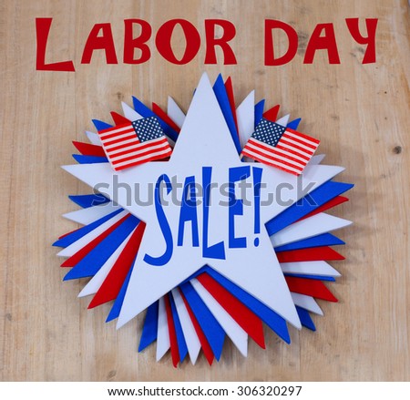 Patriotic red, white and blue image commemorating Labor Day in the United States. A swirl of stars with toothpick flags on a wooden background announcing a sales event popular on this US holiday
