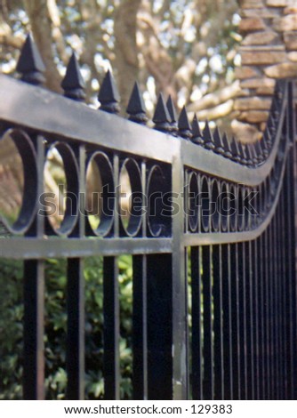 detail of wrought iron gate hung on stone post