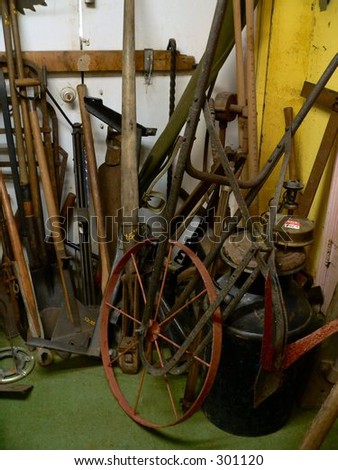 Various old tools stacked in a corner of a shed