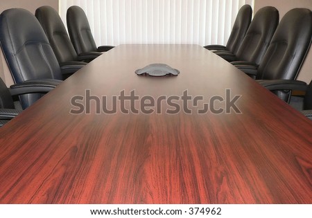boardroom table with extension speaker and chairs for at least six people darker neutrals