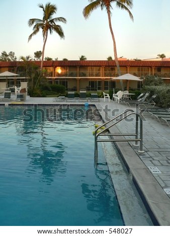 First porch light over motel pool in tropical location at twilight