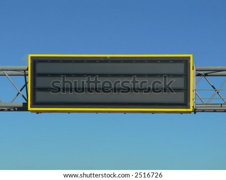 Overhead highway sign for emergency alerts like amber alerts or highway condition advisories.  The sign is blank for your own words and there is also copy space in the surrounding bright blue sky.