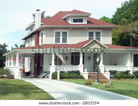 A two-story traditional American home with US flag