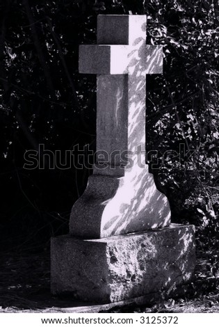 Moonlit cross in shadow in black and white