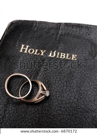 stock photo pair of wedding rings resting on old worn bible