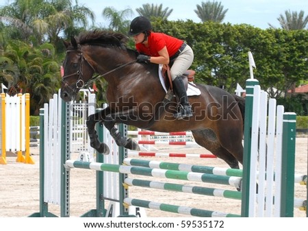 WELLINGTON, FLORIDA - AUG 21: An unidentified competitor clears a jump at the first Palm Beach County Horsemen\'s Association Show of the 2010-2011 season on August 21, 2010 in Wellington