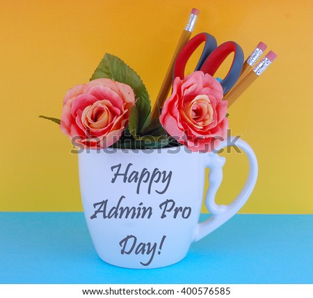 A white coffee mug filled with office supplies like pencils and a pair of scissors with a couple of silk roses on a blue and yellow background. Happy administrative professional\'??s day message