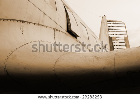 old damaged fuselage of abandoned aircraft. sepia toned.