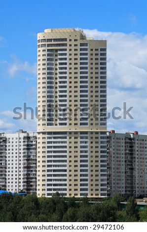 newly erected skyscraper soaring above residential buildings