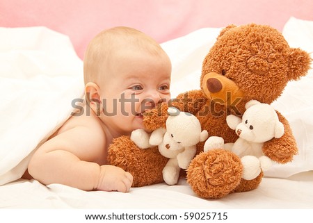 little girl bite the teddy bear in the bed