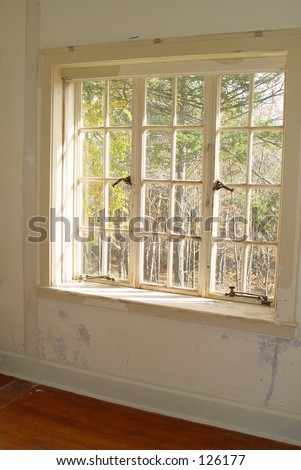Old window in haunted house with peeling white lead based paint