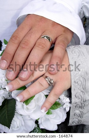 silver wedding bands over white silk gardenias and roses