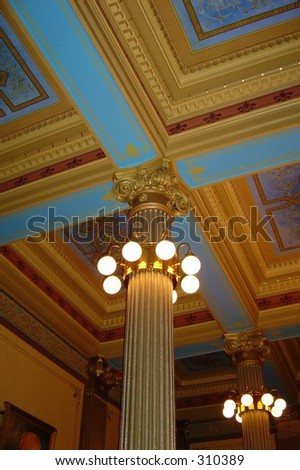 lit roman revival columns in elegant hall- painted crown molding on ceiling