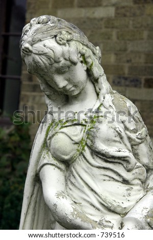 Ancient Greek or Italian gothic goddess statue in european garden.